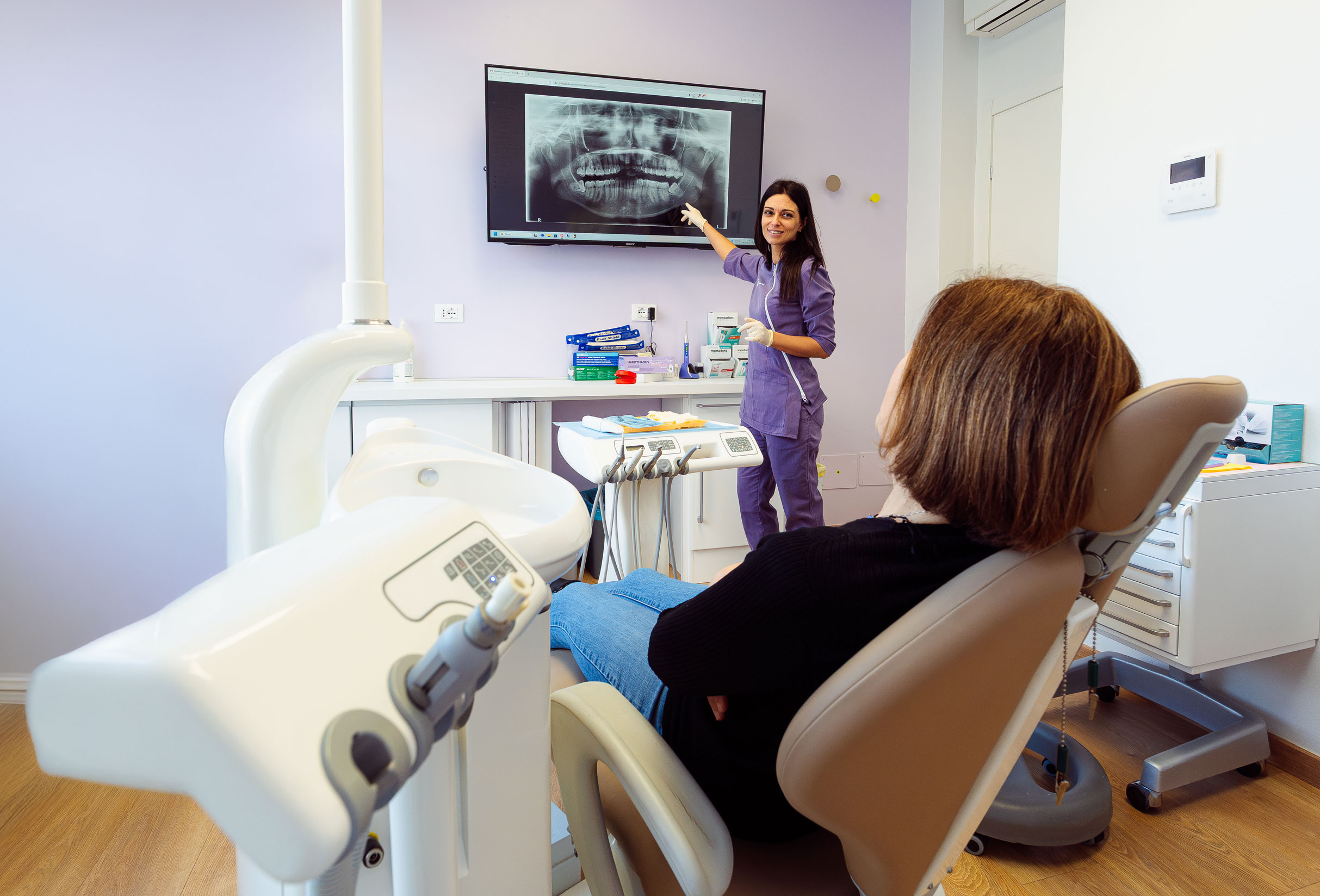 Virginia Tarrini nello studio dentistico mentre mostra una radiografia a una paziente
